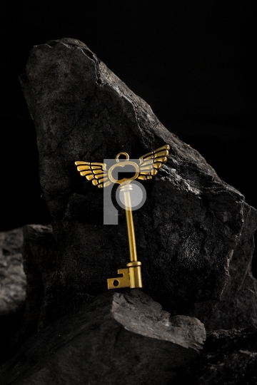 Antique Golden Key on Dark Coal Stone Surface Background