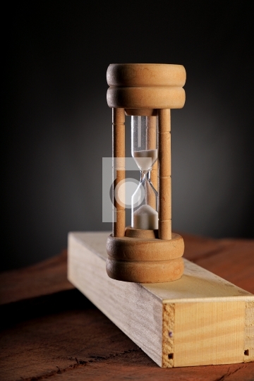Antique HourGlass Time on wood block with dark background