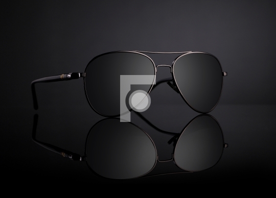 Black Aviator Sunglasses with Reflection on Black Background