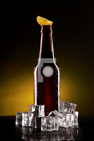 Chilled Beer Bottle with Ice Cubes and Lemon