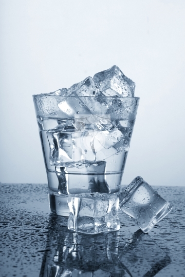 Chilled Glass of Water with Ice Cube and Water Drops