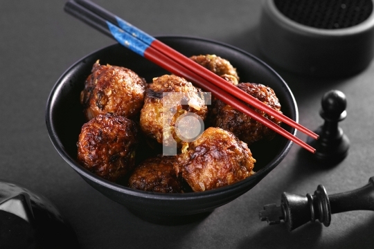 Chinese or Indian Veg Manchurian in a Black Bowl with Chopsticks
