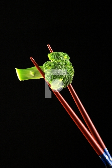 Food Broccoli on a Chop Sticks on Black Background