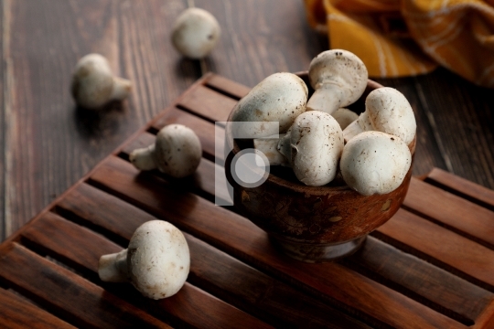 Fresh Uncooked Organic Button Mushrooms in a Wooden Bowl