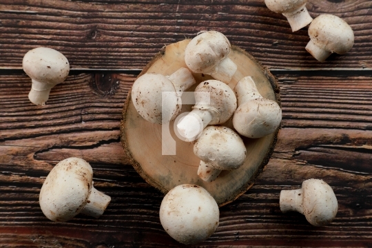 Fresh Uncooked Organic Button Mushrooms in a wooden tray