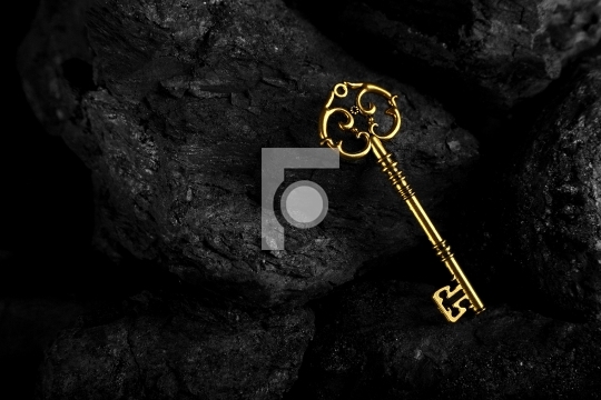 Golden Antique Key on Black Stone Background