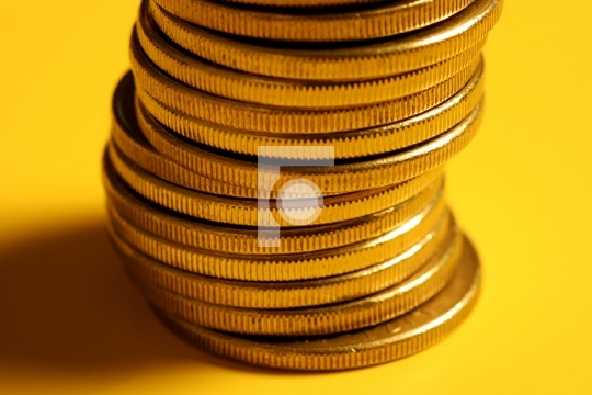 golden coin stacked on yellow background