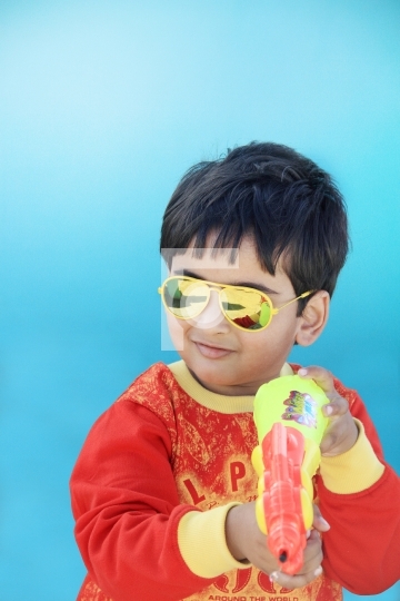Indian Boy Celebrating Holi with Water Gun - Festival of Colours