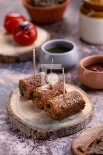 Indian Food Chicken Seekh Kebab on a Wooden Platter with Sauce