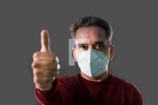 Indian Man wearing a N95 mask and showing thumbs up for protecti