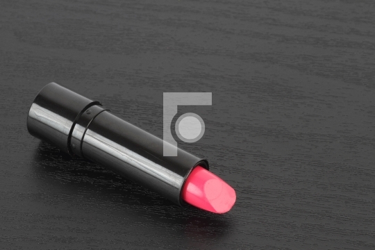 Lipstick / Lip Gloss on a Black Wooden Background