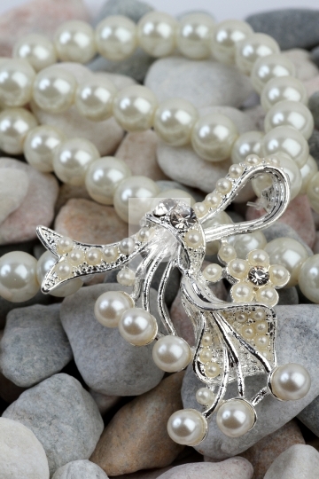 Pearl jewelery on stones background
