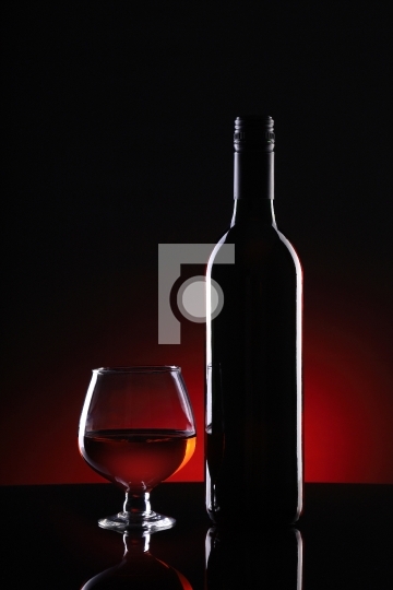 Red Wine Bottle and Glass on Dark Background