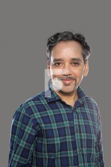 Smiling Indian Man in Casual shirt in 40s on grey background