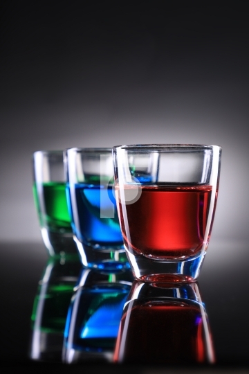 Three Colorful Shot Glasses on Grey Background