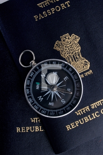 two indian passports and a magnetic compass