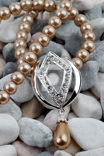 Pearl, diamond jewelery on stones background